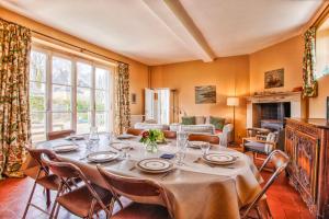 uma sala de jantar com uma mesa e cadeiras e uma lareira em La Rabouillère - House in Omaha Beach em Commes