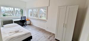 1 dormitorio con 1 cama, escritorio y ventanas en EFDE GmbH- Studenten und Business WG-Zimmer ab sofort frei 3-er WG inkl. Reinigungservice, en Heilbronn