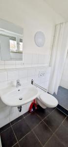 łazienka z białą umywalką i toaletą w obiekcie EFDE GmbH- Studenten und Business WG-Zimmer ab sofort frei 3-er WG inkl. Reinigungservice w mieście Heilbronn