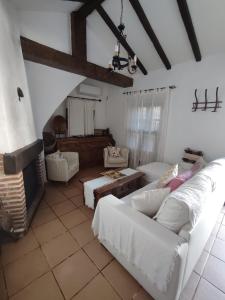 a living room with white couches and a fireplace at La Pintoresca y la Casita in El Colmenar