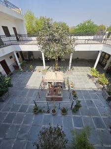 um pátio com uma mesa e uma árvore num edifício em Krishna dhaam bungalow Goverdhan, Mathura em Rādha Kund