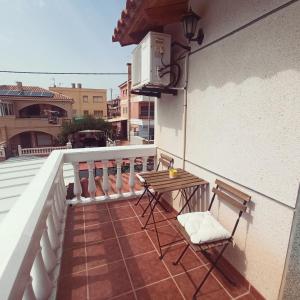 - un balcon avec deux chaises et une table dans un bâtiment dans l'établissement Junto a la playa con mesa de Ping Pong y tabla Paddle Surf - By Aloha Palma, à Calabardina