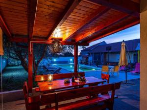 a patio with a wooden table and a pool at Holiday Home Villa Vesna Lux in Zadar