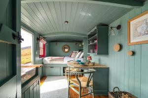 a tiny house with a bedroom and a table at Barlwyd Glamping in Blaenau-Ffestiniog