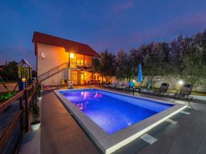 a swimming pool in front of a house at Holiday Home Villa Vesna Lux in Zadar