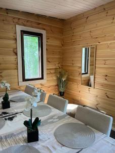 uma sala de jantar com uma mesa e cadeiras e uma janela em Kodikas mökki lähellä luontoa Nurmijärven Perttulassa em Nurmijärvi