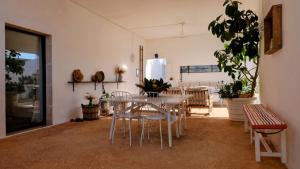 uma sala de jantar com uma mesa branca e cadeiras em Masseria Pezze Galere Piscina privata em Montalbano