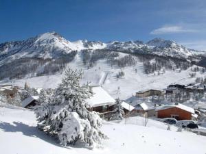 einen schneebedeckten Berg mit einer Skihütte in der Ferne in der Unterkunft Studio Montgenèvre, 1 pièce, 4 personnes - FR-1-445-26 in Montgenèvre