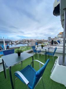 a balcony with tables and chairs and a view of a harbor at Experiencia en el mar Gijon C in Gijón