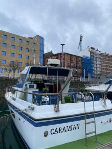 a white boat is docked in a harbor at Experiencia en el mar Gijon C in Gijón