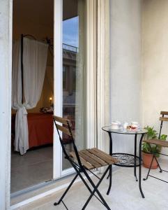 uma cadeira e uma mesa numa varanda em KATY CHARME Apartment SELF CHECK-IN em Pisa