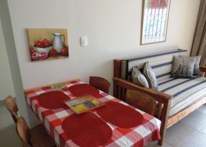 a bedroom with a bed with a red and white blanket at Blue Mountain Bay in Simonʼs Town