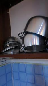 two pans sitting on a shelf in a kitchen at L&A Homes in Kisii