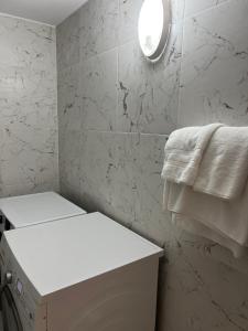 ein weißes Bad mit einem weißen Handtuch an der Wand in der Unterkunft Apartment Villa Virginia in Berat