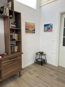 Zimmer mit Bücherregal und Tisch in der Unterkunft Apartment Villa Virginia in Berat