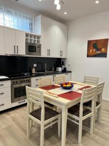 eine Küche mit einem Tisch und Stühlen sowie eine Küche mit weißen Schränken in der Unterkunft Apartment Villa Virginia in Berat