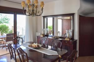 a dining room with a table and a mirror at Kiki’s 3BD apt. with Citrus Garden & BBQ in Gastoúni