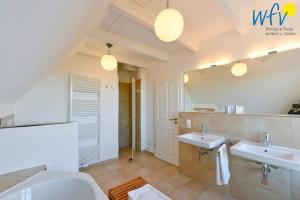 un bagno con due lavandini e un grande specchio di Landhaus Ostdüne Ferienwohnung Dünenmeer a Juist Altre 30 foto
