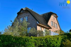 una grande casa in mattoni con tetto a gambero di Landhaus Ostdüne Ferienwohnung Dünenmeer a Juist