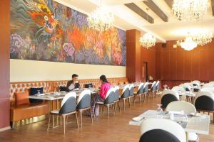 two people sitting at tables in a dining room at Kaachi Grand Hotel in Paro