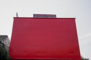 a red wall with a sign on top of it at Octave Verdisso Hotel in Bangalore