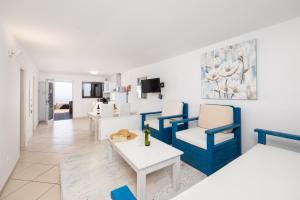 a living room with blue chairs and a table at Villa Oasis de Asomada in La Asomada