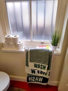 a bathroom with a window with towels and a toilet at Urban Oasis Loft in Bradford