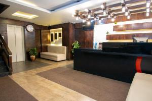 a lobby with a bar with a chair and a clock at Octave Verdisso Hotel in Bangalore
