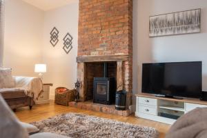 a living room with a fireplace and a tv at Ashtree Farm in Durham