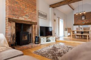 a living room with a fireplace and a tv at Ashtree Farm in Durham