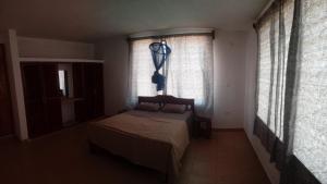 a bedroom with a bed and two windows at Gemini Villas in Kijiwetanga