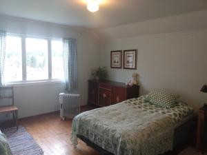 - une chambre avec un lit, une commode et des fenêtres dans l'établissement 1940s house in Vestre Toten, à Boverbru