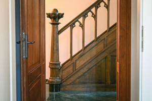 un escalier avec rampe et porte en bois dans l'établissement Mühlen-Apartment, à Xanten