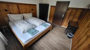 um quarto com uma cama com lençóis brancos e almofadas em Haus Grübl em Wald im Pinzgau