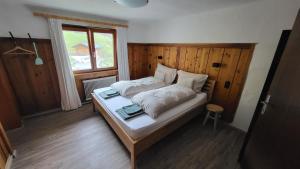 Bett in einem Zimmer mit Fenster in der Unterkunft Haus Grübl in Wald im Pinzgau