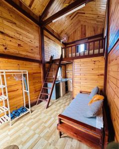 a bedroom of a log cabin with a bed and a ladder at TopView Măng Đen in Kon Von Kla