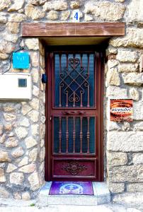 une porte en bois avec une porte dans un mur en pierre dans l'établissement Rivendel, à Poyales del Hoyo