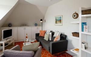 ein Wohnzimmer mit einem Sofa und einem TV in der Unterkunft Ferienwohnung Seefeder in Morsum