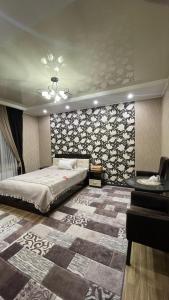 a bedroom with a large bed and a couch at Отель Чынгыз 2 in Osh