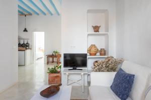a living room with a white couch and a tv at La Casa del Agua in Altea