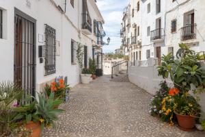 an alley in an old town with flowers in pots at La Casa del Agua in Altea