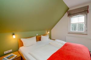 ヴェスターラントにあるFerienwohnung Südwindのベッドルーム1室(赤毛布、窓付)
