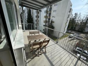 Elle comprend un balcon avec une table et des chaises en bois. dans l'établissement Berlinhome Apartment Steglitz, à Berlin