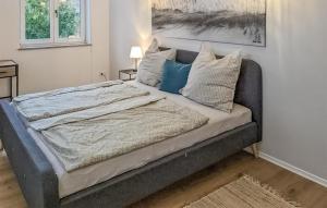 a large bed with blue pillows in a bedroom at Stunning Apartment In Bad Heilbrunn in Bad Heilbrunn +2 photos