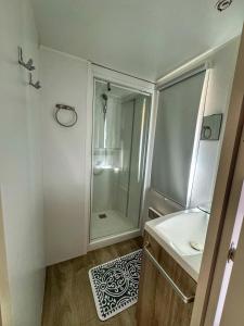 een badkamer met een douche en een wastafel bij Grand Mobile-Home 6 Places climatisé in Munster