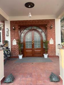 a brick building with a wooden door with two plants at The Sparkling Turtle Backpackers Hostel in Kathmandu