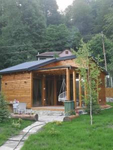 Cette petite maison en bois dispose d'une terrasse couverte et d'une balançoire. dans l'établissement Wooden Mountain Villa, à Berovo