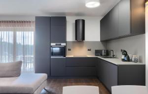 a kitchen with black and white cabinets and a couch at Villa-Venus in Višnjan
