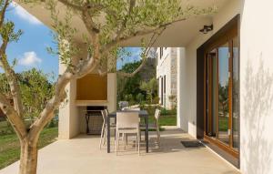 a patio with a table and chairs next to a tree at Villa-Venus in Višnjan