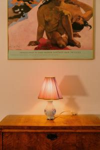 a lamp on a wooden table with a painting on the wall at 4ry pokoje in Cieszyn